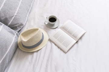 Open book  and cup of coffee in bed 