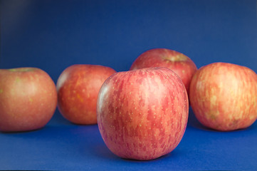 Pink ripe apples on a blue background