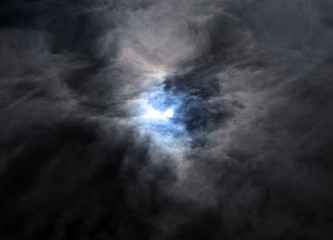 Reflection of the moon and sky in the water. Full moon in the dark sky. Thunderclouds in the sky. Reflection of the sun in the water. The sun comes out of the clouds. Dramatic background.
