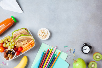 Back to school concept. Healthy lunch box and colorful stationery on table top view.