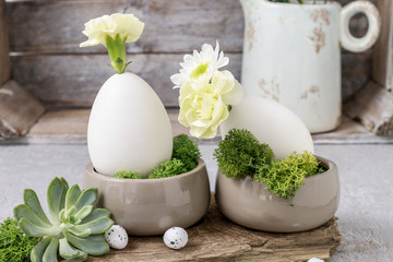 Floral arrangement with goose egg, carnations, chrysanthemum and moss.