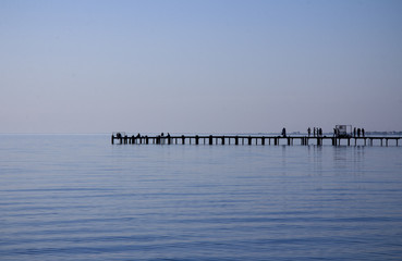 The silhouette of the pier between the sky and the sea