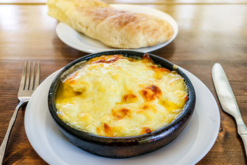 Fried suluguni cheese. Georgian national dish in a clay plate.