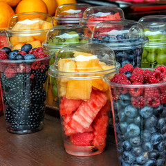 fresh organic berries: blackberries, raspberries, watermelon in transparent glasses on the table for sale.
