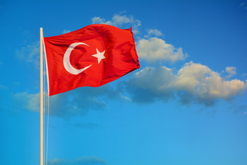 Flag of Turkey waving in the wind against evening blue sky.