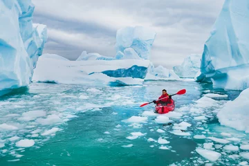 Foto op Canvas extreme tourism, winter kayaking in Antarctica, adventurous man paddling on sea kayak between icebergs © Song_about_summer