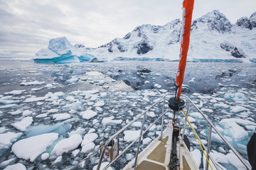 sailing boat in Antarctica, yacht navigation through icebergs and sea ice © Song_about_summer