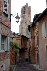 Fototapeta premium Albi street in a rainy day with the cathedral at the background
