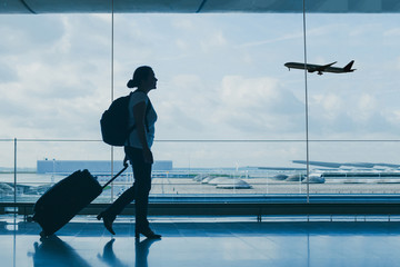 airport travel, silhouette of people at international departure terminal, flight