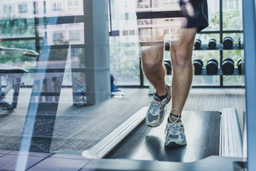 feet of runner on treadmill, sport exercises in fitness center, workout training, man on running...