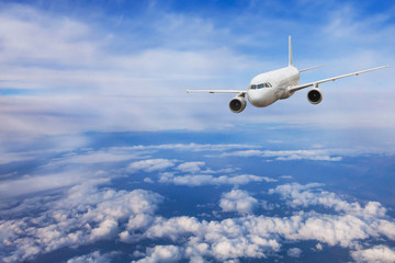 Fototapeta premium samolot lecący nad chmurami, koncepcja podróży, samolot odrzutowy w błękitne niebo