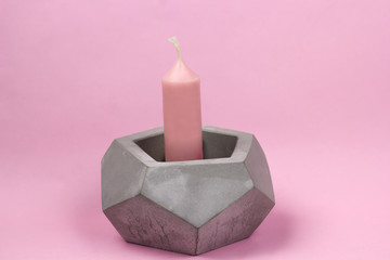 pinkcandle in concrete pot pink background