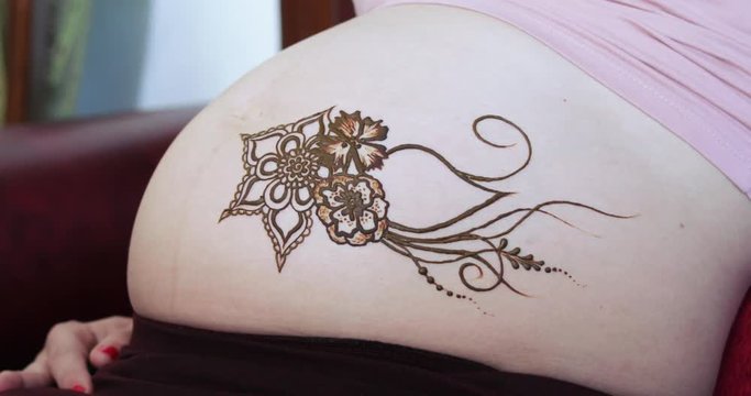 Drawing a mehendi on the stomach
