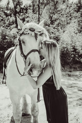 Nice lady at countryside with white horse. A beautiful rider and horse. Artistic Photography at horse farm. Attractive woman riding on horse rural location