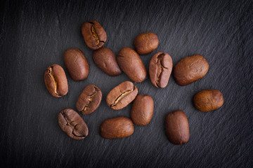 Obraz premium Coffee beans on black slate background