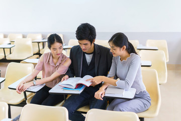 Fototapeta premium Students man and woman reading book preapare for exam highschool in classroom at school. concept of education people learning and tutorial academy.