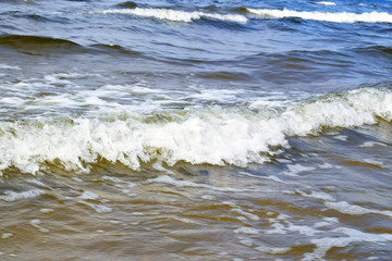Wave with white foam of the Baltic Sea.  Coastline, storm, surf.