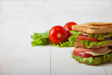 sandwich, tomato, toast, salad  on white wooden background