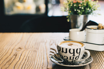 Cappuccino placed on the wooden table. Should drink coffee in the afternoon because the body will start to fatigue. Drinking coffee during this time we will benefit from full caffeine.
