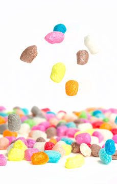 Multicolored cornballs pour down on the table. A game for children. Flight. Manipulation