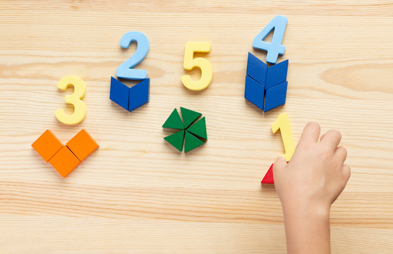 The child is studying the numbers and the account. Arranges the colored blocks to the desired numbers. Mathematics for children