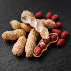fresh peanuts on a dark stone background