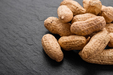 fresh peanuts on a dark stone background