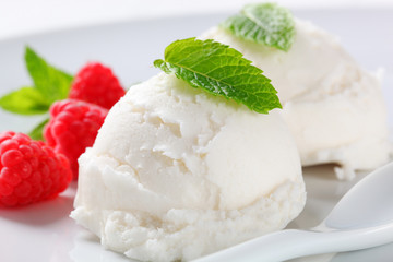 Scoops of white ice cream with raspberries