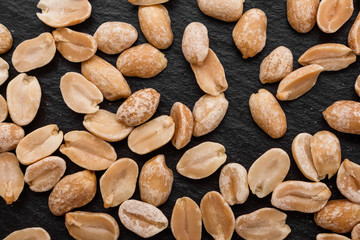 Obraz premium fresh peanuts on a dark stone background