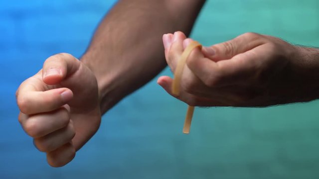 Stretching an elastic rubber band to its limit and breaking it.