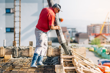 Industrial worker using concrete pipe pump for building house