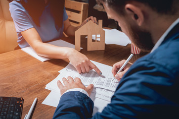 Man sign a home insurance policy on home loans. Estate agent with customer before contract...