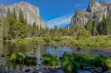 Fototapeta na wymiar Merced river flowing in Yosemite valley hidden between granite mountains Yosemite National Park, California, USA
