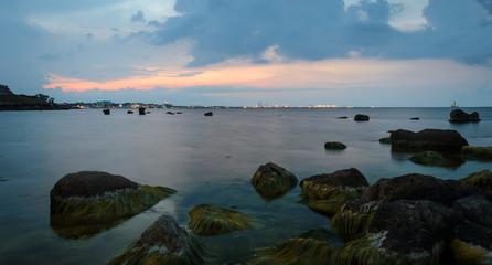 Calm sea in the evening,  city lights in the distance