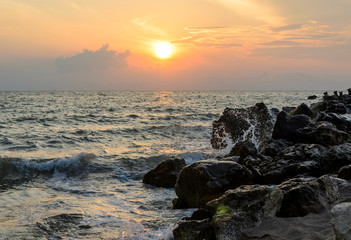 Waves splashing rocks at sunrise