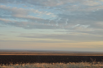horizon aux traces de nuages gris et orange au crépuscule sur des champs labourés un beau jour d'automne