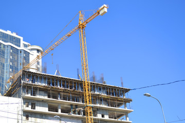 Fototapeta premium Construction of an apartment house with a crane.