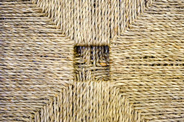 A woven Mat of reeds or straw-yellow in color. The texture of dry cane. Light yellow.