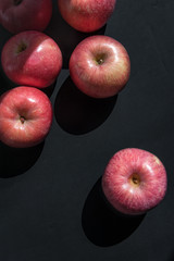 Pink apples on a black surface