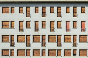 Concrete facade with series of facade of windows and small balconiesConcrete facade with series of...