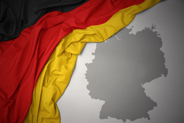 waving colorful national flag and map of germany.