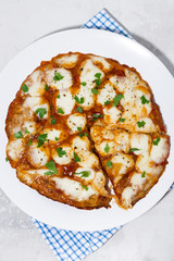pizza with mozzarella on a white plate, vertical top view