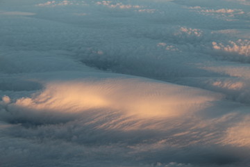 Obraz premium Dense cloud wave partially lit by sunlight