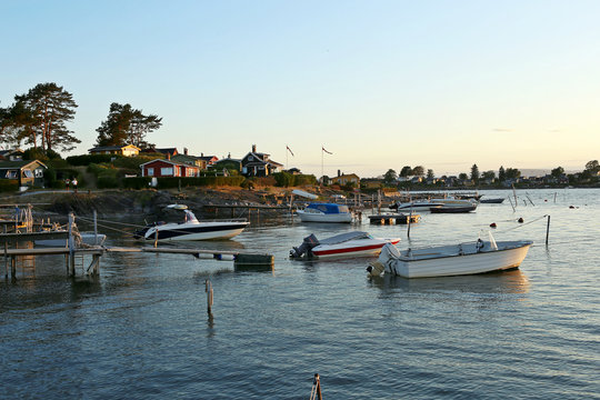 Motor boats in the marina in sunset. Lindoya island with summer cottages and marina in Oslo Fjord, Norway.