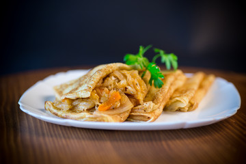 thin fried pancakes stuffed with stewed cabbage in a plate