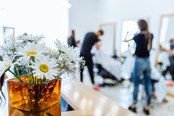 haircut saloon on background. chamomile in vase close up
