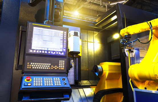 part of the cnc milling machine with control panel and robot in motion blur moves a part from the CNC on the conveyor