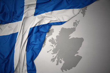 waving colorful national flag and map of scotland.