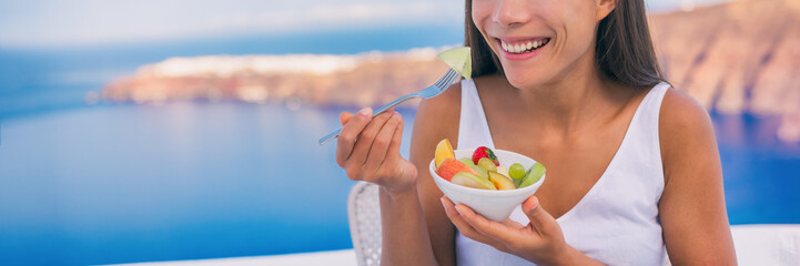 Healthy eating woman breakfast fruit bowl. Banner panorama of girl with fruits salad bowl on travel...