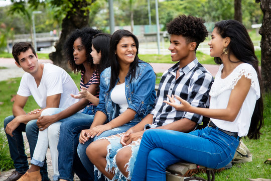 Native Latin American Woman And African Man Talking With Caucasian Friends Outdoor In The Summer In The City